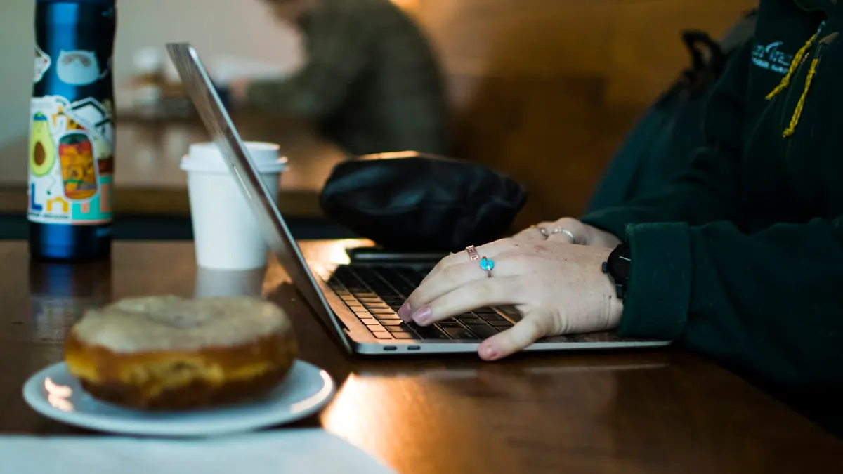 Professional sending an application email from a café
