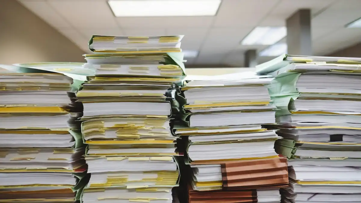 Saudi Iqama Renewal 2026: Fees, Absher Steps, Penalties & Rules Office worker handling documents – iqama renewal fees and paperwork